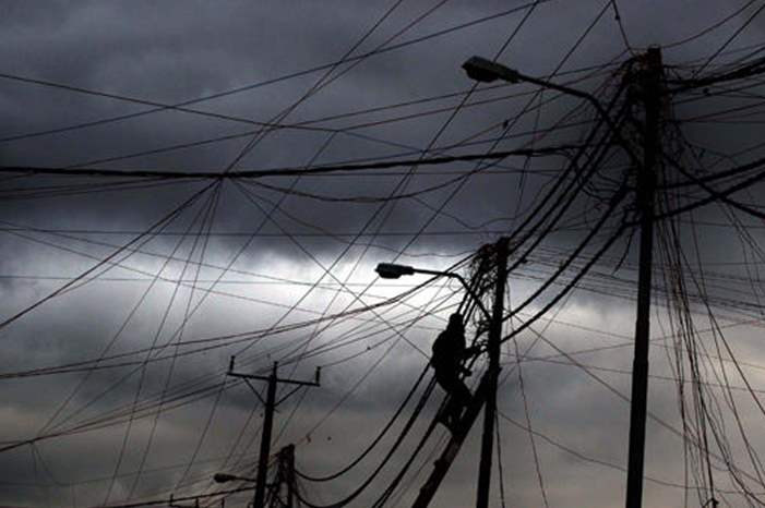 عامل كهرباء يصلح أعطالا بسبب الظروف الجوية -%28تصوير محمد أبو غوش%29