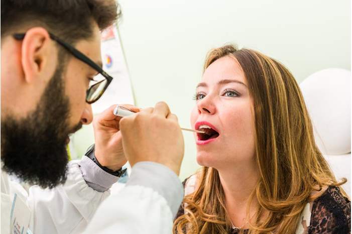 woman-with-green-tongue-being-inspected-by-dentist-or-doctor