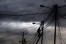 عامل كهرباء يصلح أعطالا بسبب الظروف الجوية -%28تصوير محمد أبو غوش%29