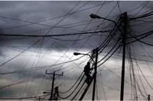 عامل يقوم بصيانة أحد أعمدة الكهرباء خلال منخفض سابق- %28أرشيفية تصوير%3A محمد أبو غوش%29